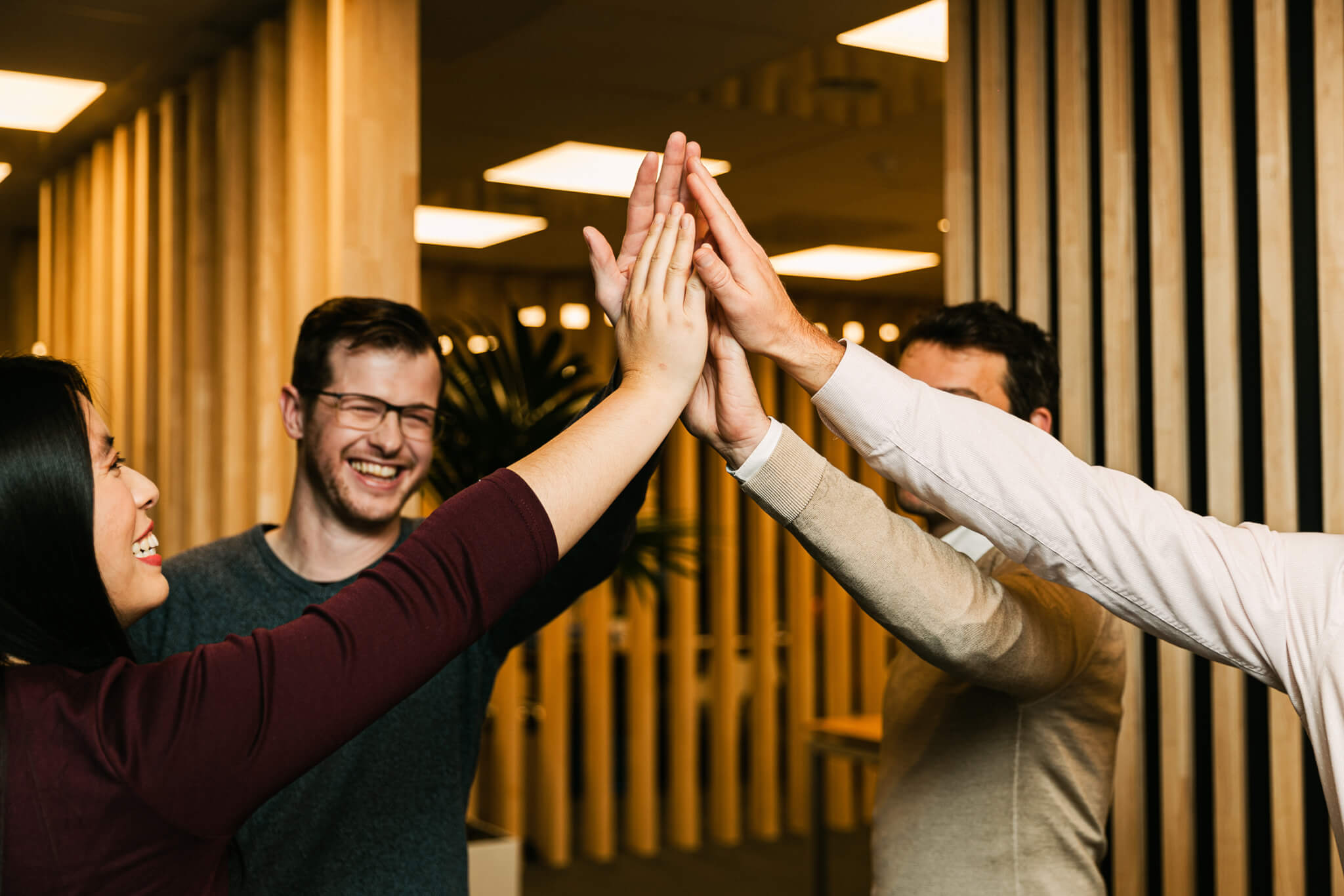 4 threon employees giving eachother a high-five